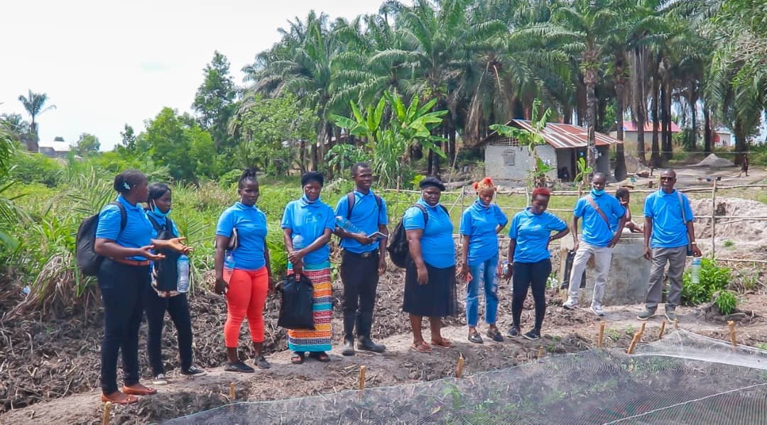Training participants standing beside farm ponds